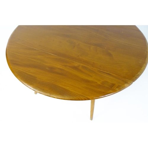 1631 - Vintage / Retro: An elm Ercol drop flap table with two demi lune leaves raised on four tapering legs... 