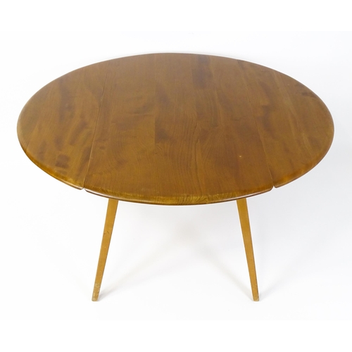 1631 - Vintage / Retro: An elm Ercol drop flap table with two demi lune leaves raised on four tapering legs... 