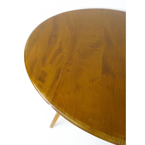 1631 - Vintage / Retro: An elm Ercol drop flap table with two demi lune leaves raised on four tapering legs... 