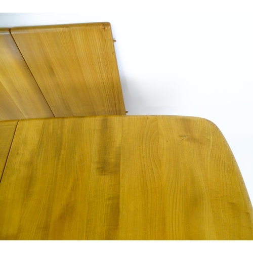 1633 - Vintage / Retro: An elm Ercol extending dining table raised on five tapering splayed legs. 60