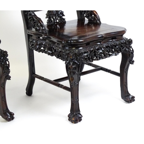 1452 - A pair of late 19thC / early 20thC Chinese hardwood side chairs with intricately carved frames depic... 