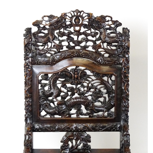 1452 - A pair of late 19thC / early 20thC Chinese hardwood side chairs with intricately carved frames depic... 