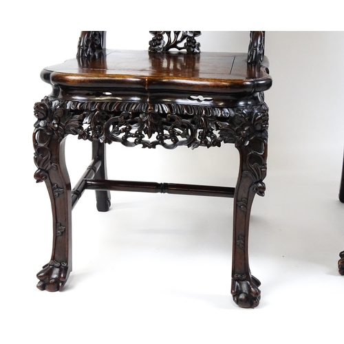 1452 - A pair of late 19thC / early 20thC Chinese hardwood side chairs with intricately carved frames depic... 