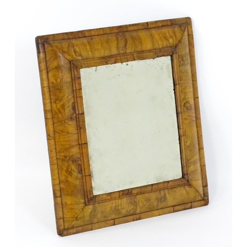 1462 - An early 18thC walnut cushion mirror with a bevelled glass set within a moulded frame. 22