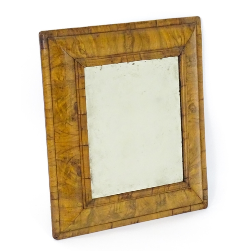 1462 - An early 18thC walnut cushion mirror with a bevelled glass set within a moulded frame. 22