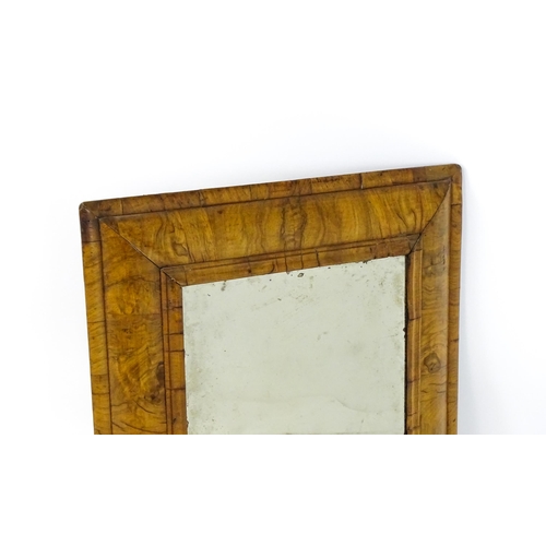 1462 - An early 18thC walnut cushion mirror with a bevelled glass set within a moulded frame. 22