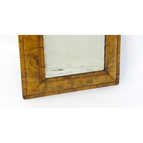 1462 - An early 18thC walnut cushion mirror with a bevelled glass set within a moulded frame. 22