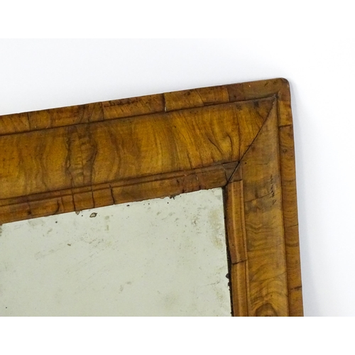 1462 - An early 18thC walnut cushion mirror with a bevelled glass set within a moulded frame. 22