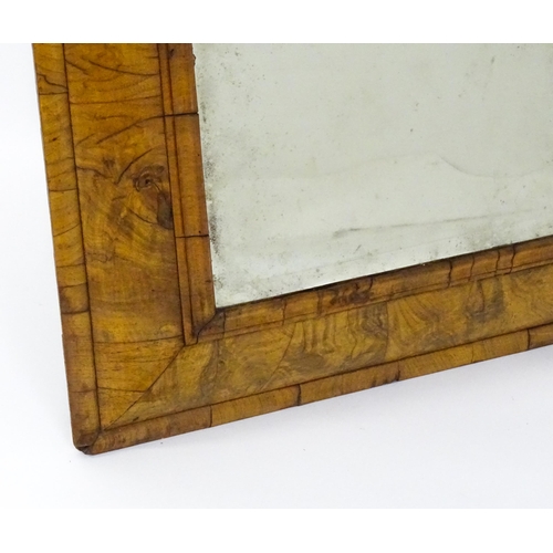 1462 - An early 18thC walnut cushion mirror with a bevelled glass set within a moulded frame. 22