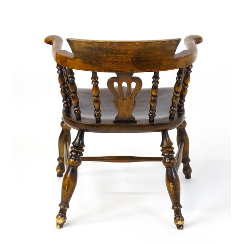 1478 - A late 19thC / early 20thC smokers bow armchair with a pierced vase shaped back splat alongside turn... 