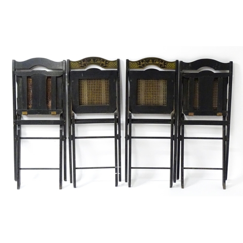 1491 - A set of four early 20thC lacquered folding chairs with chinoiserie decoration and caned seats. 16