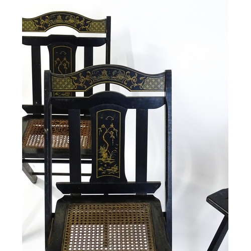 1491 - A set of four early 20thC lacquered folding chairs with chinoiserie decoration and caned seats. 16