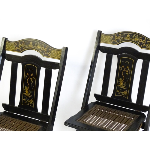 1491 - A set of four early 20thC lacquered folding chairs with chinoiserie decoration and caned seats. 16