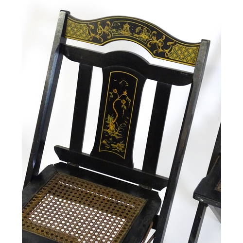 1491 - A set of four early 20thC lacquered folding chairs with chinoiserie decoration and caned seats. 16