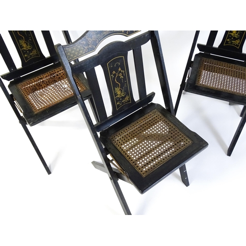 1491 - A set of four early 20thC lacquered folding chairs with chinoiserie decoration and caned seats. 16