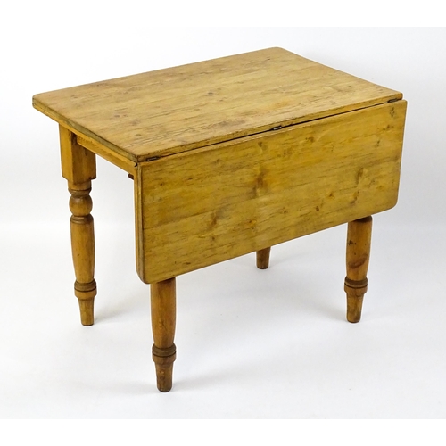 1497 - An early 20thC pine table with a single drop leaf raised on four turned tapering legs. 35