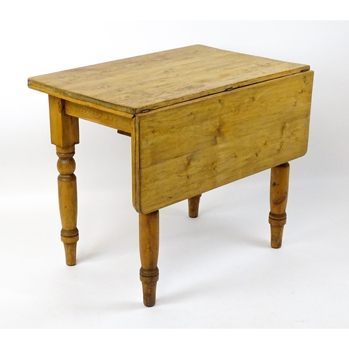 1497 - An early 20thC pine table with a single drop leaf raised on four turned tapering legs. 35