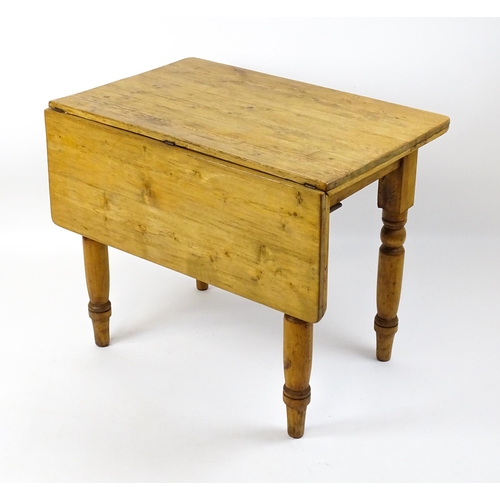 1497 - An early 20thC pine table with a single drop leaf raised on four turned tapering legs. 35