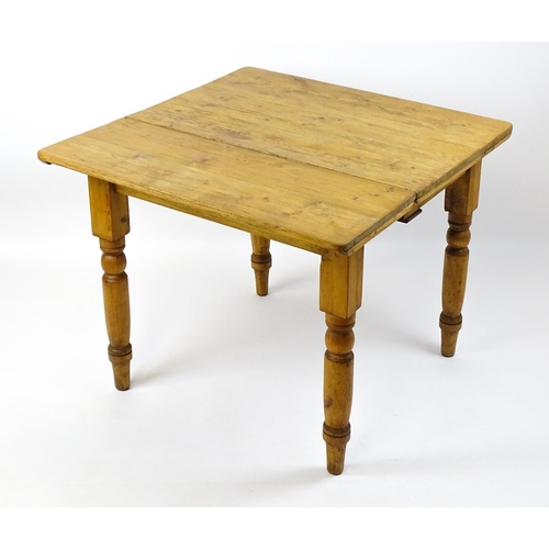 1497 - An early 20thC pine table with a single drop leaf raised on four turned tapering legs. 35