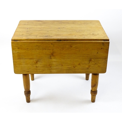 1497 - An early 20thC pine table with a single drop leaf raised on four turned tapering legs. 35