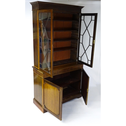 1503 - A late 19thC / early 20thC mahogany bookcase with a moulded fluted cornice above two astragal glazed... 