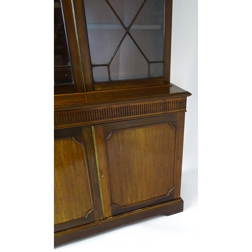 1503 - A late 19thC / early 20thC mahogany bookcase with a moulded fluted cornice above two astragal glazed... 