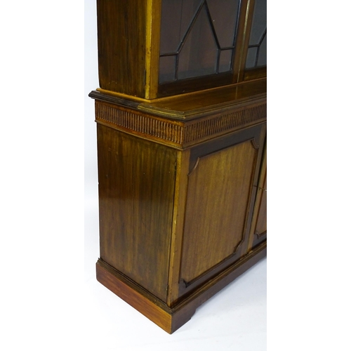 1503 - A late 19thC / early 20thC mahogany bookcase with a moulded fluted cornice above two astragal glazed... 