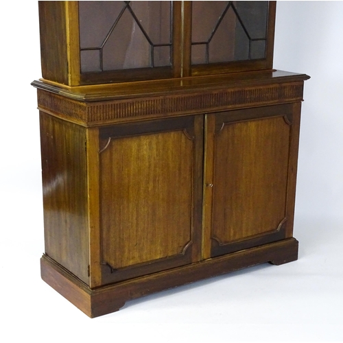 1503 - A late 19thC / early 20thC mahogany bookcase with a moulded fluted cornice above two astragal glazed... 