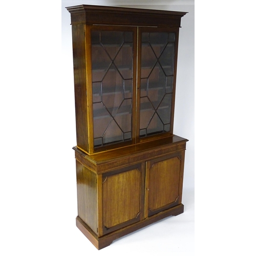 1503 - A late 19thC / early 20thC mahogany bookcase with a moulded fluted cornice above two astragal glazed... 