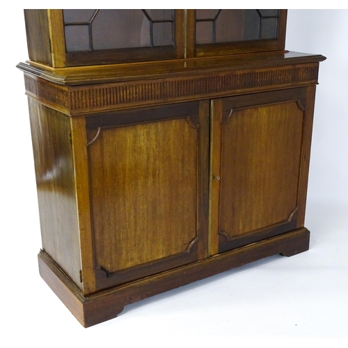 1503 - A late 19thC / early 20thC mahogany bookcase with a moulded fluted cornice above two astragal glazed... 