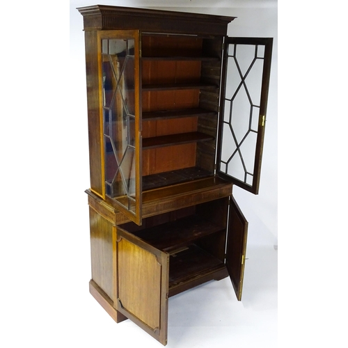 1503 - A late 19thC / early 20thC mahogany bookcase with a moulded fluted cornice above two astragal glazed... 