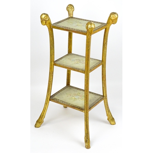 1530 - A William Kent style etagere with three tiers raised on splayed supports with rams head terminals an... 