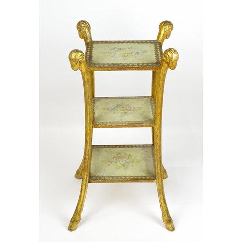 1530 - A William Kent style etagere with three tiers raised on splayed supports with rams head terminals an... 