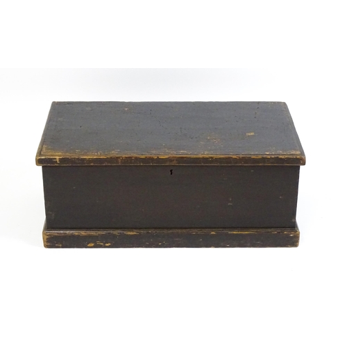 1615 - An early 19thC black painted pine trunk flanked by wrought iron carrying handles, the hinged lid ope... 