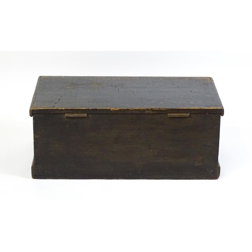 1615 - An early 19thC black painted pine trunk flanked by wrought iron carrying handles, the hinged lid ope... 