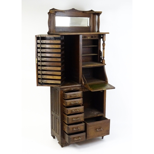 1444 - A late 19thC oak dentist cabinet in the manner of Harvard & Co. The cabinet having a mirrored top se... 