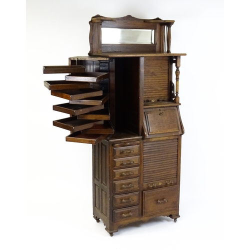 1444 - A late 19thC oak dentist cabinet in the manner of Harvard & Co. The cabinet having a mirrored top se... 