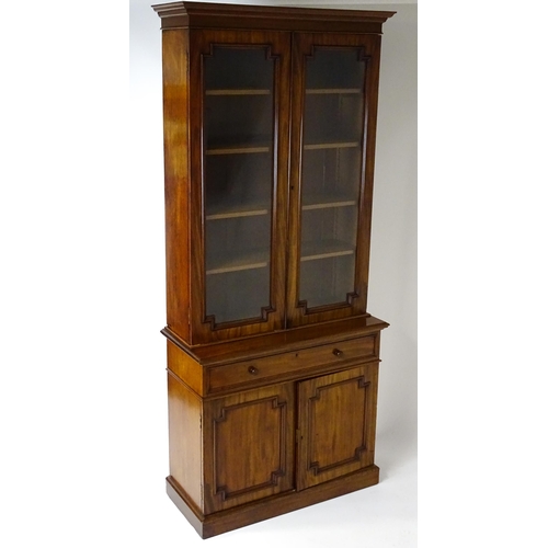 1445 - A Victorian mahogany bookcase with a moulded cornice above a glazed top and four adjustable shelves,... 