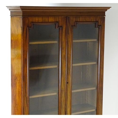 1445 - A Victorian mahogany bookcase with a moulded cornice above a glazed top and four adjustable shelves,... 