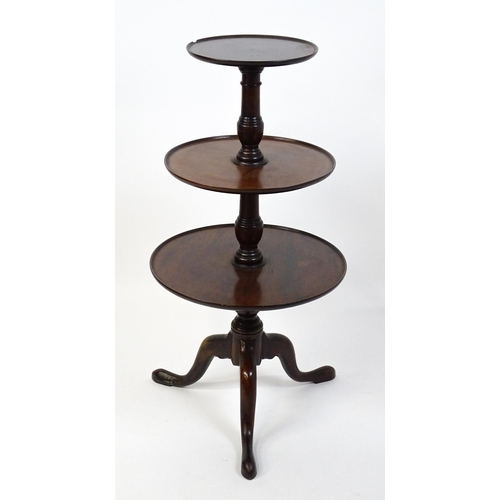 1477 - A Georgian mahogany dumb waiter with three circular tiers raised on a turned pedestal and three cabr... 