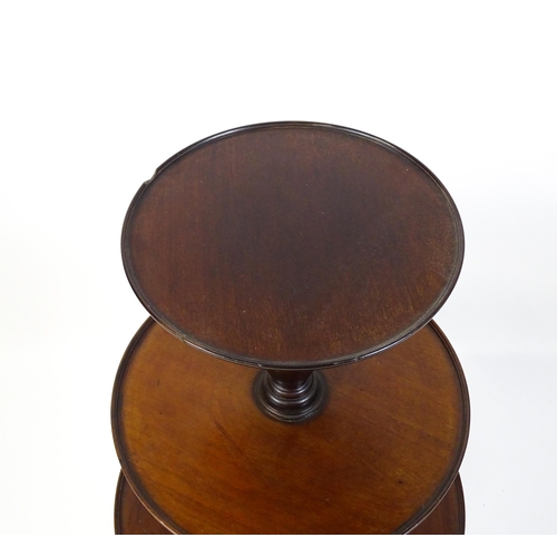 1477 - A Georgian mahogany dumb waiter with three circular tiers raised on a turned pedestal and three cabr... 