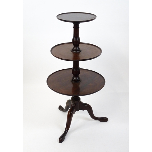 1477 - A Georgian mahogany dumb waiter with three circular tiers raised on a turned pedestal and three cabr... 