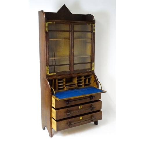 1480 - A late 19thC oak Arts & Crafts bureau bookcase with a pointed pediment above glazed doors and brass ... 