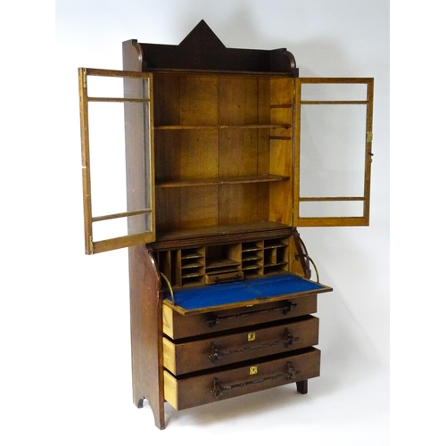 1480 - A late 19thC oak Arts & Crafts bureau bookcase with a pointed pediment above glazed doors and brass ... 