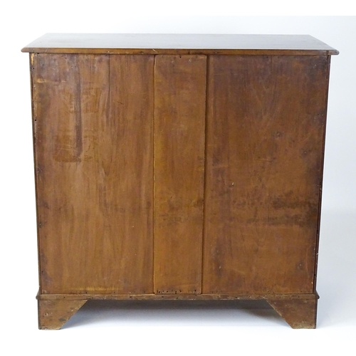 1498 - A mid 20thC mahogany cabinet with a moulded top above two panelled doors raised on ogee bracket feet... 