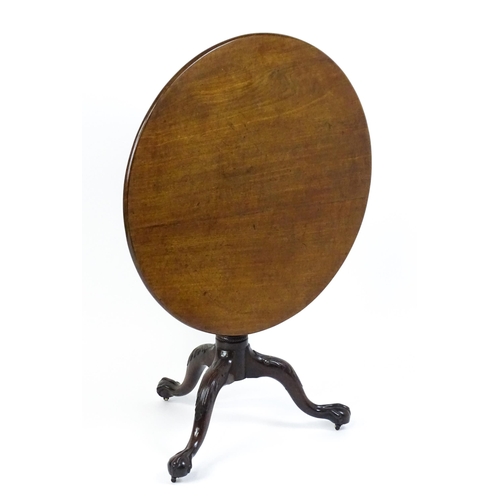 1507 - A George III mahogany tripod table with a circular top above a turned pedestal raised on three acant... 