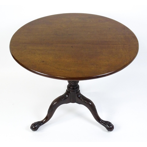 1507 - A George III mahogany tripod table with a circular top above a turned pedestal raised on three acant... 