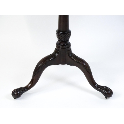 1507 - A George III mahogany tripod table with a circular top above a turned pedestal raised on three acant... 