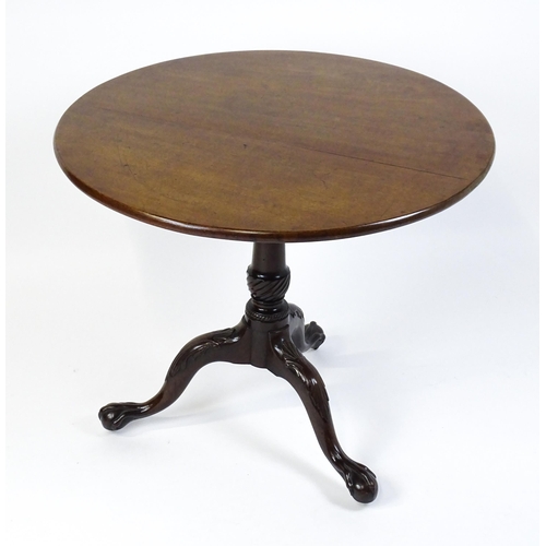 1507 - A George III mahogany tripod table with a circular top above a turned pedestal raised on three acant... 