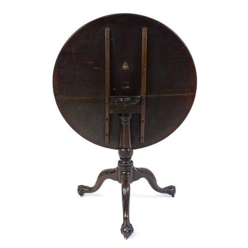 1507 - A George III mahogany tripod table with a circular top above a turned pedestal raised on three acant... 